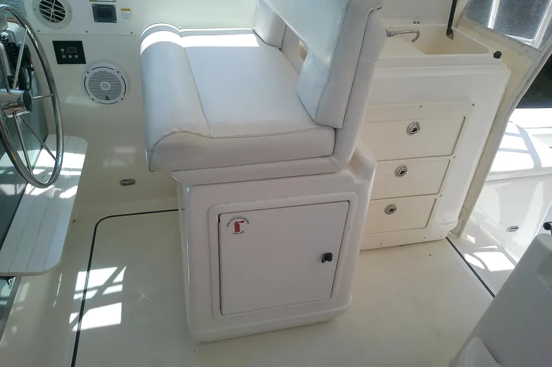 Slide: The Image of Interior of a 2000 Tiara Yachts 4100 Open, featuring helm seat and storage drawers. - 34