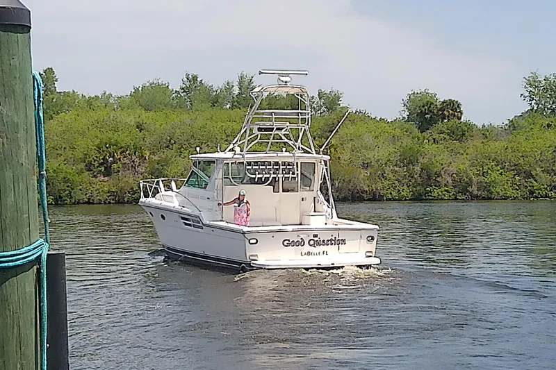 Slide: The Image of 2000 Tiara Yachts 4100 Open cruising on a river, labeled "Good Question," LaBelle, FL. - 4