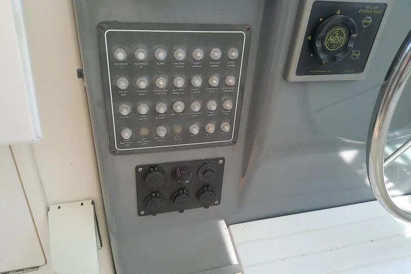 Slide: The Image of Control panel of a 2000 Tiara Yachts 4100 Open, featuring various switches and dials. - 44