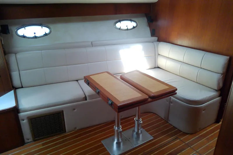 Slide: The Image of Interior of 2000 Tiara Yachts 4100 Open with white seating and wooden table. - 46