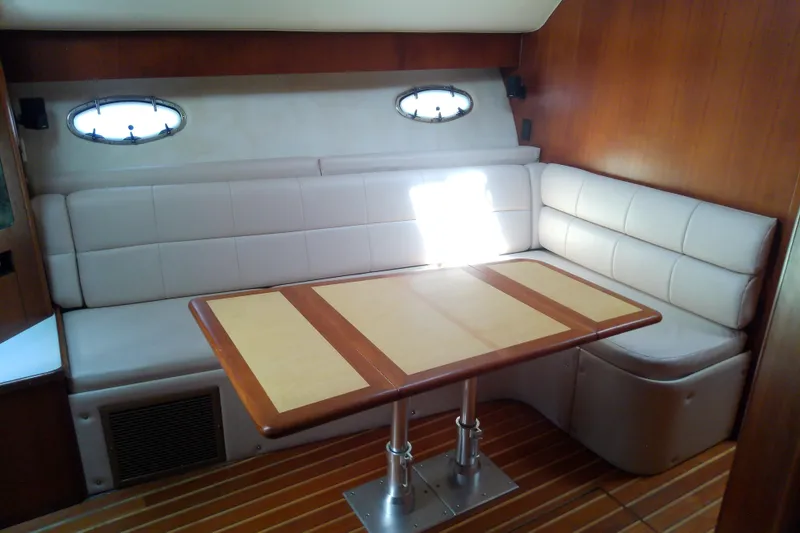 Slide: The Image of Interior of 2000 Tiara Yachts 4100 Open with cushioned seating and wooden table. - 47