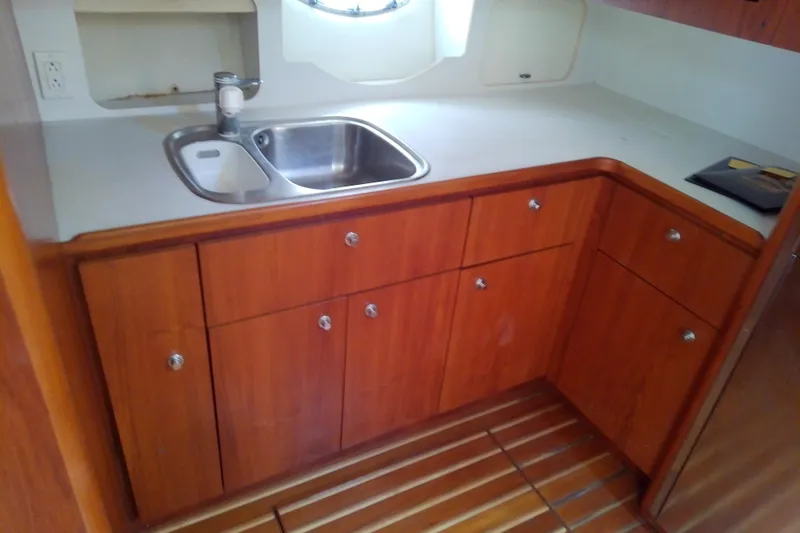 Slide: The Image of Wooden yacht kitchen with sink, cabinets, and countertop on a 2000 Tiara Yachts 4100 Open. - 49