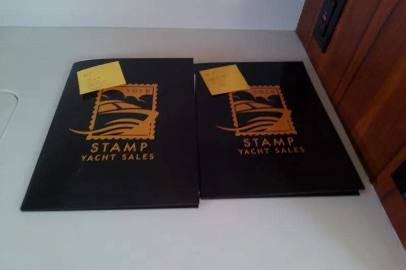 Slide: The Image of Two Stamp Yacht Sales folders on a table, featuring Tiara Yachts 4100 Open, 2000 model. - 50