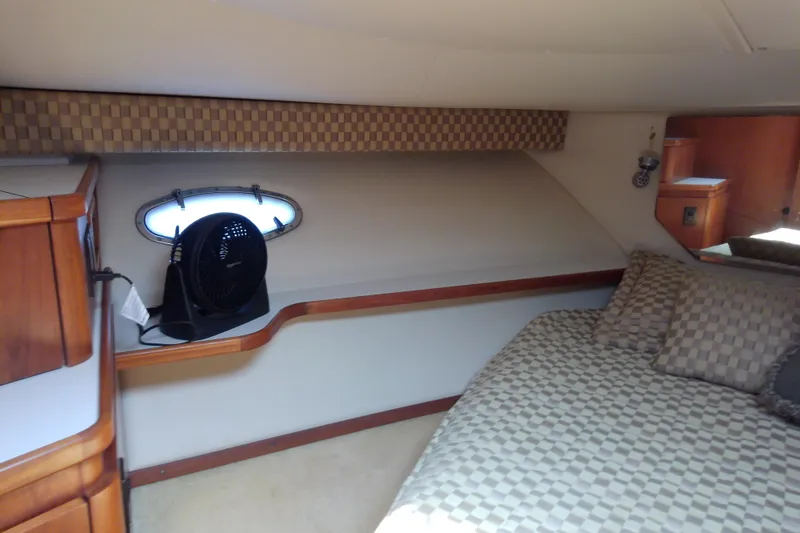 Slide: The Image of Cozy cabin interior of 2000 Tiara Yachts 4100 Open with checkered bedding and wooden accents. - 59