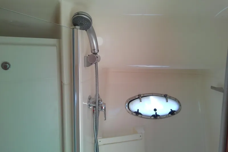 Slide: The Image of Shower area in 2000 Tiara Yachts 4100 Open, featuring a handheld showerhead and porthole. - 67
