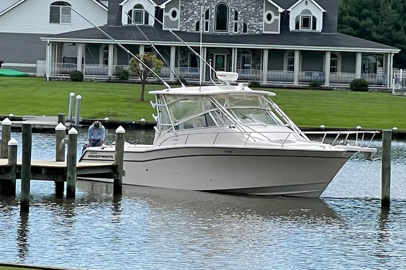 The Image of 2007 Grady-White Express 330 docked near a large house. - 0