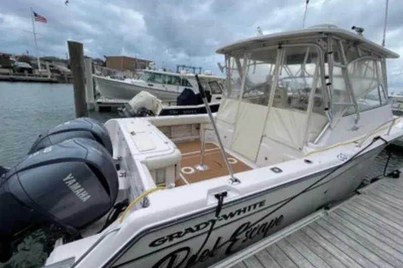 Slide: The Image of 2007 Grady-White Express 330 boat docked with Yamaha engines, cloudy sky. - 12
