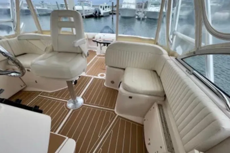 Slide: The Image of 2007 Grady-White Express 330 boat interior with white seating and wood-patterned flooring. - 15