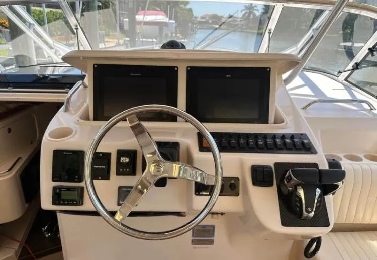 Slide: The Image of 2007 Grady-White Express 330 helm with dual screens and steering wheel. - 2