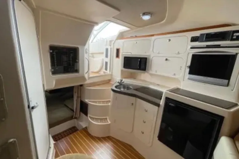 Slide: The Image of 2007 Grady-White Express 330 cabin interior with kitchenette, microwave, and TV. - 35