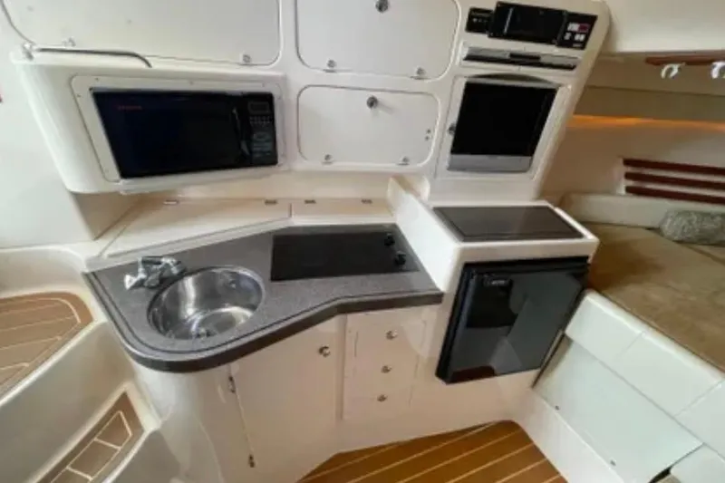 Slide: The Image of 2007 Grady-White Express 330 boat interior kitchen with sink, stove, and microwave. - 36