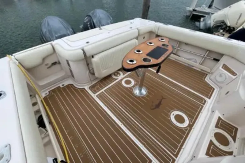 Slide: The Image of 2007 Grady-White Express 330 boat deck with seating and table, docked by the water. - 53