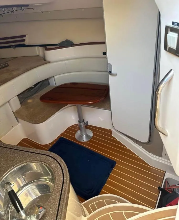Slide: The Image of 2007 Grady-White Express 330 cabin interior with wood flooring and compact dining area. - 6