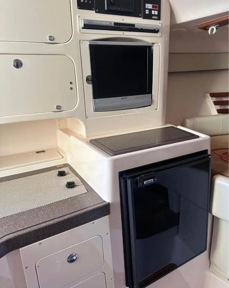 Slide: The Image of 2007 Grady-White Express 330 interior with kitchenette, fridge, and TV. - 7