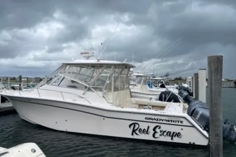 Slide: The Image of 2007 Grady-White Express 330 boat named "Reel Escape" docked under cloudy skies. - 9