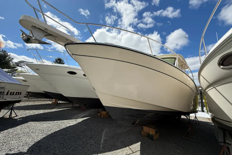 The Image of 2021 Grady-White Express 330 boat on stands under a blue sky with clouds. - 0