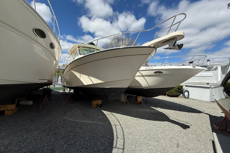 Slide: The Image of 2021 Grady-White Express 330 boat on dry dock under a partly cloudy sky. - 2