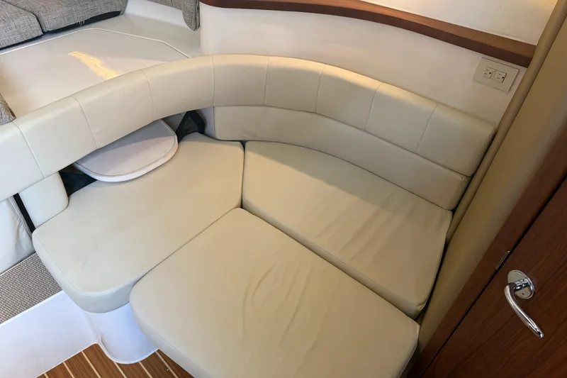 Slide: The Image of 2021 Grady-White Express 330 cabin interior with beige seating and wooden accents. - 20