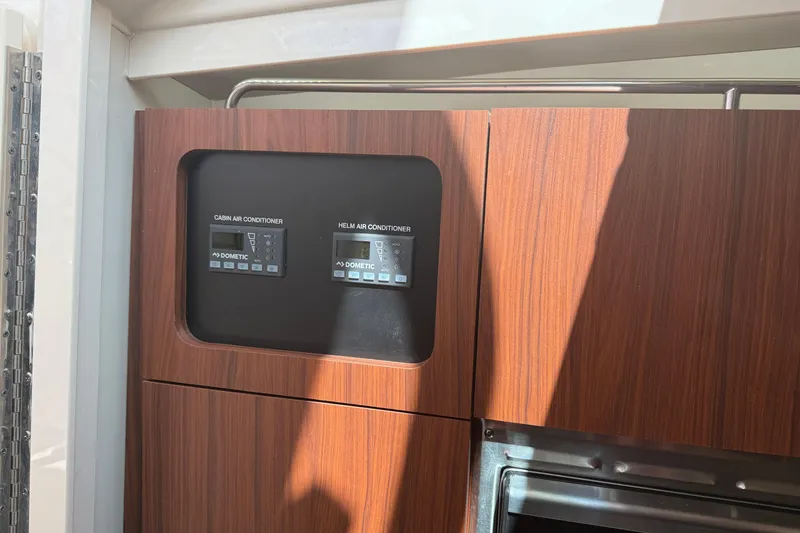 Slide: The Image of 2021 Grady-White Express 330 cabin and helm air conditioner controls. - 21