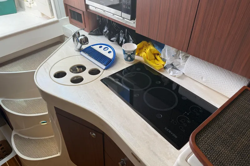 Slide: The Image of 2021 Grady-White Express 330 boat kitchen with stove, sink, and storage. - 25