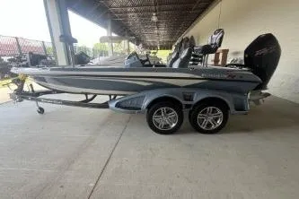 The Image of 2026 Ranger Z519R Cup-Equipped boat, sleek design, dual-axle trailer, parked under shelter. - 0