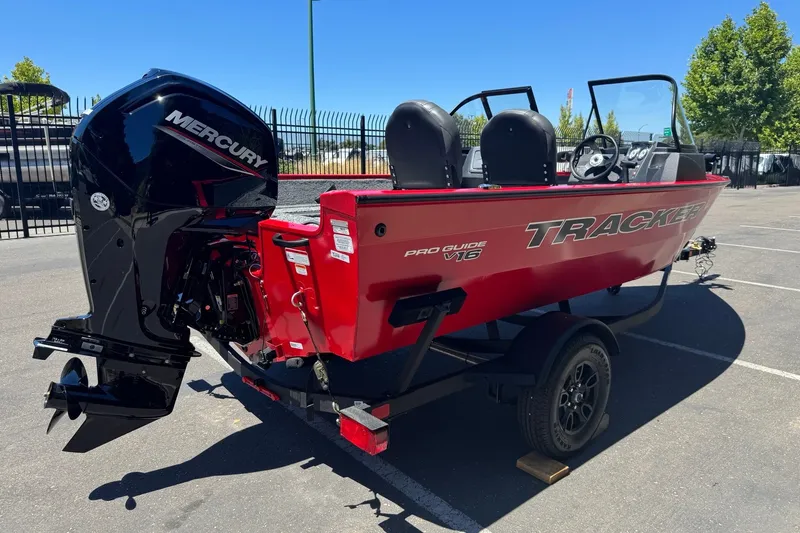 Slide: The Image of 2026 Tracker Pro Guide V-16 WT boat with Mercury engine, parked outdoors. - 5