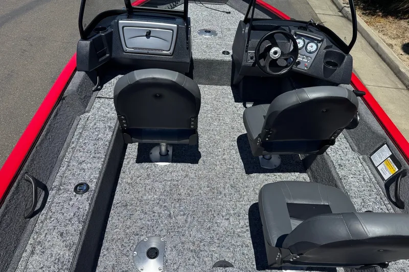 Slide: The Image of 2026 Tracker Pro Guide V-16 WT boat interior with gray seating and dashboard controls. - 10