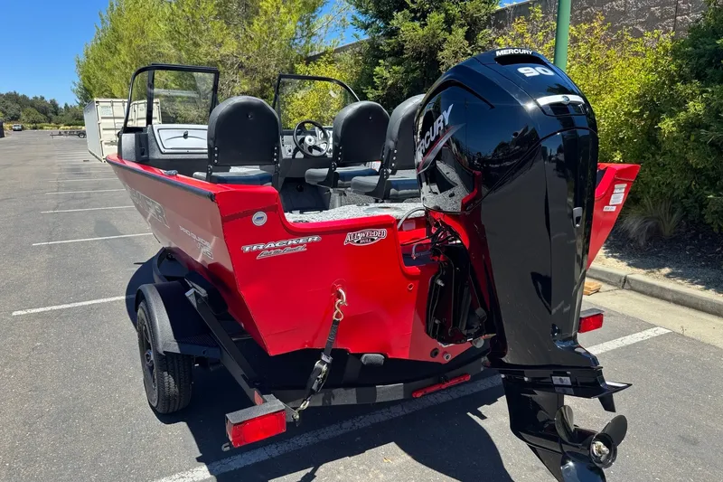 Slide: The Image of 2026 Tracker Pro Guide V-16 WT boat with Mercury 90 engine in a parking lot. - 3
