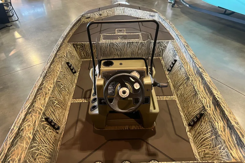 Slide: The Image of 2026 Tracker Grizzly 1860 CC boat interior with camouflage design and steering console. - 3