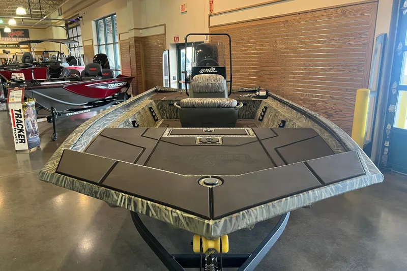 Slide: The Image of 2026 Tracker Grizzly 1860 CC boat displayed in showroom with camo design. - 2
