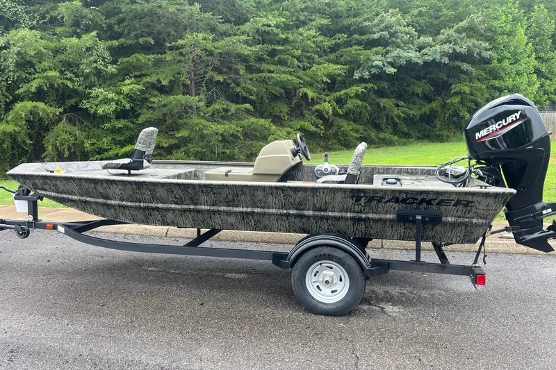 The Image of 2026 Tracker Grizzly 1754 SC boat with Mercury engine on trailer, parked outdoors. - 0