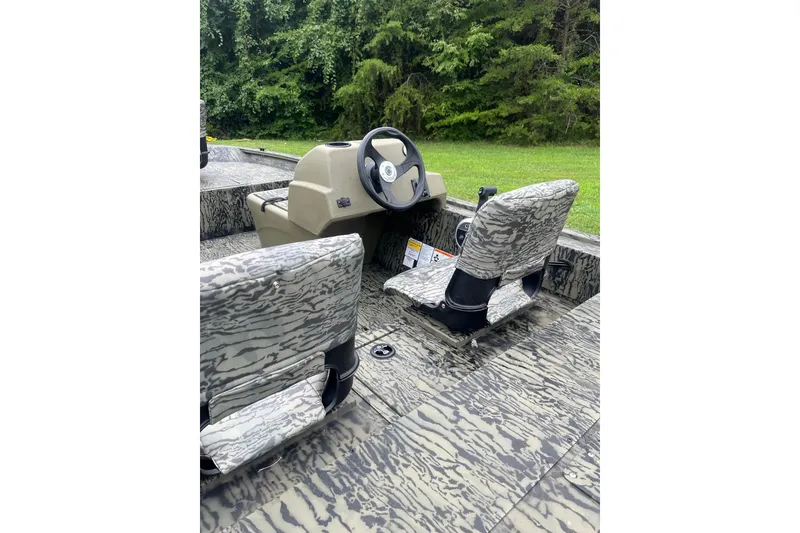 Slide: The Image of 2026 Tracker Grizzly 1754 SC boat interior with camouflage seats and steering console. - 3