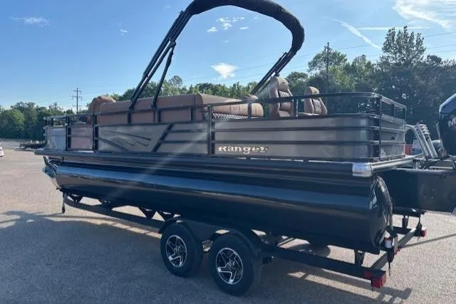 Slide: The Image of 2026 Ranger 220F pontoon boat on trailer, parked outdoors under clear sky. - 6