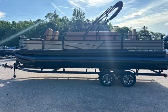 Slide: The Image of 2026 Ranger 220F pontoon boat on trailer, parked outdoors under a clear sky. - 7