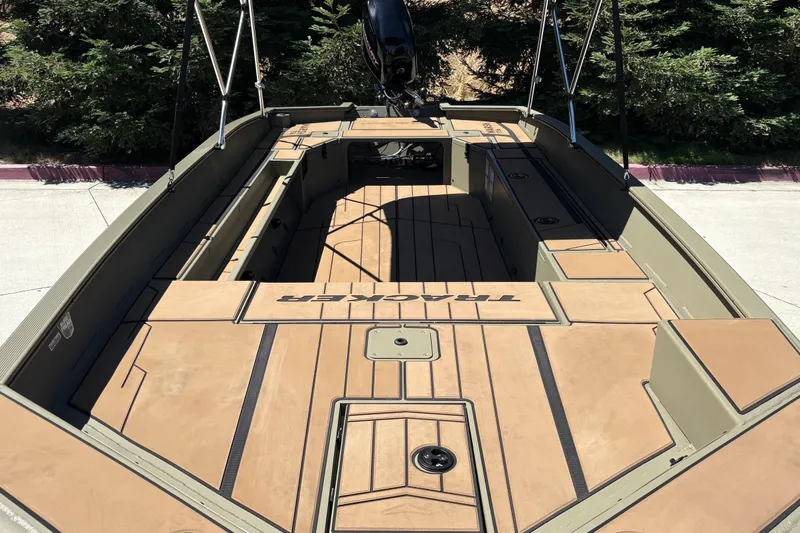Slide: The Image of 2026 Tracker Grizzly 1756 T Marsh boat with spacious deck and seating, parked outdoors. - 9