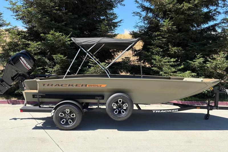 The Image of 2026 Tracker Grizzly 1756 T Marsh boat on trailer, parked outdoors. - 0