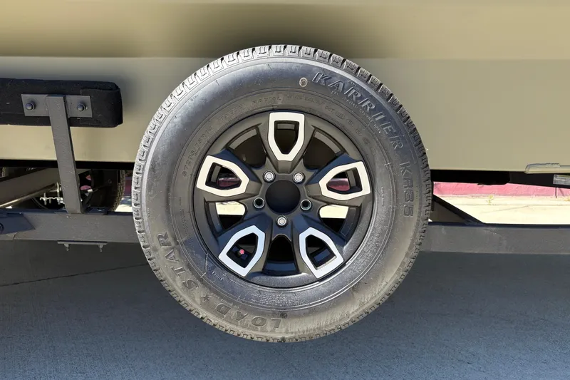Slide: The Image of Trailer wheel of 2026 Tracker Grizzly 1756 T Marsh, featuring Karriker KR35 tire. - 2