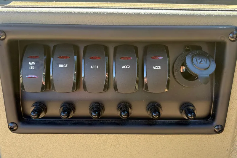 Slide: The Image of Control panel of 2026 Tracker Grizzly 1756 T Marsh boat with switches and 12V outlet. - 3
