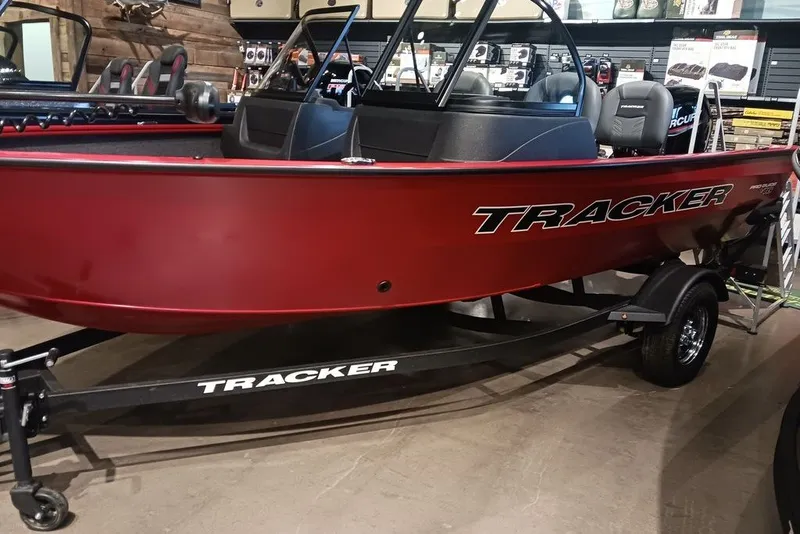 Slide: The Image of 2026 Tracker Pro Guide V-16 WT boat in showroom, red exterior, on trailer. - 18