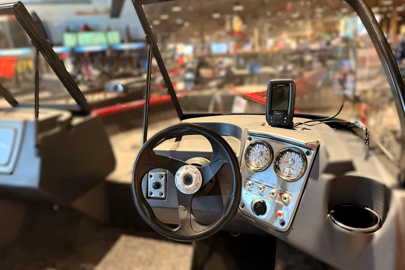 Slide: The Image of Interior view of 2026 Tracker Pro Guide V-16 WT boat dashboard with steering wheel and gauges. - 48