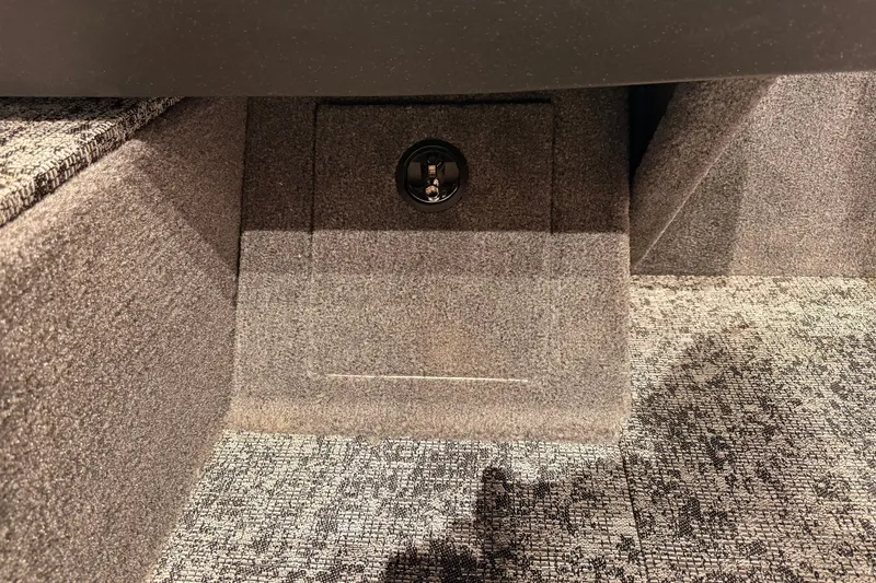 Slide: The Image of Carpeted interior of 2026 Tracker Pro Guide V-16 WT boat, featuring storage compartment. - 60