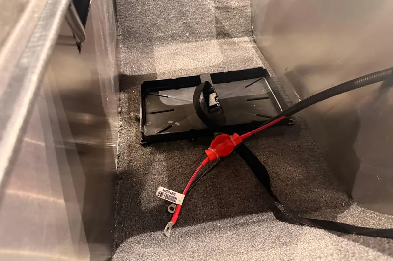 Slide: The Image of Battery compartment of 2026 Tracker Pro Guide V-16 WT boat, featuring wiring and mounting bracket. - 54