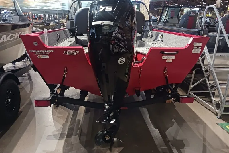 Slide: The Image of 2026 Tracker Pro Guide V-16 WT boat with a powerful 75 HP engine, displayed indoors. - 19