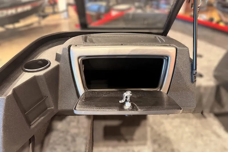 Slide: The Image of 2026 Tracker Pro Guide V-16 WT dashboard with open storage compartment and cup holder. - 55