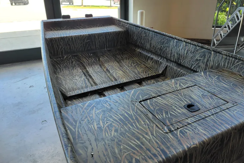 Slide: The Image of 2026 Tracker Grizzly 15 Jon boat with camouflage design in a showroom. - 4