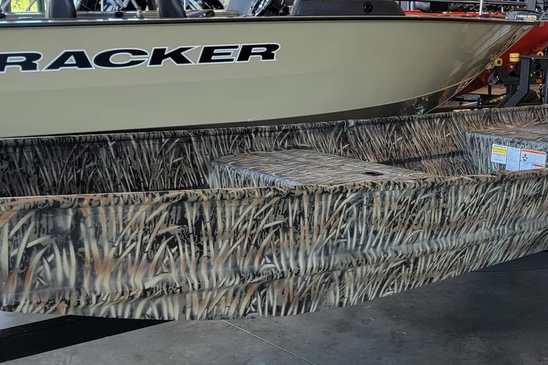 Slide: The Image of 2026 Tracker Grizzly 15 Jon boat with camouflage design in showroom. - 5