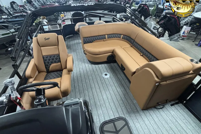 Slide: The Image of 2026 Ranger 223FC boat interior with tan and black seating, steering wheel, and spacious layout. - 7