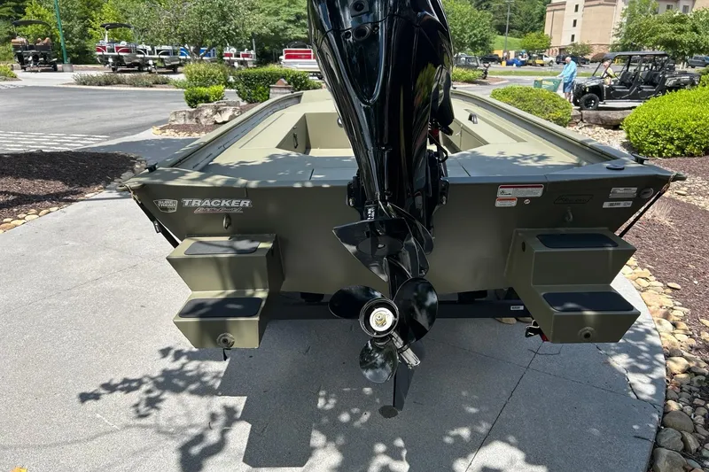 Slide: The Image of 2026 Tracker Grizzly 1654 T Sportsman boat with motor, parked outdoors. - 2