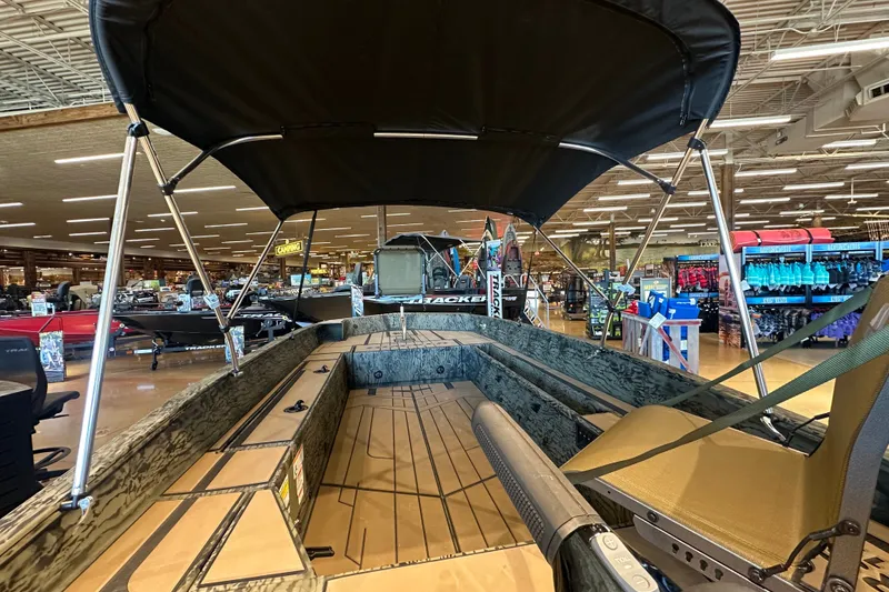 Slide: The Image of 2026 Tracker Grizzly 1756 T Marsh boat displayed in a showroom with canopy and seating. - 41