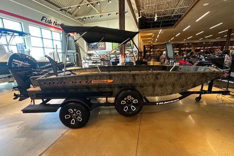 The Image of 2026 Tracker Grizzly 1756 T Marsh boat displayed indoors with Mercury engine. - 27